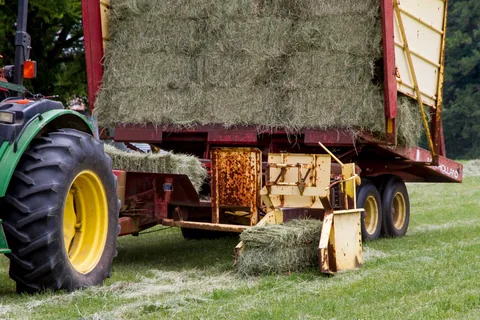 A square hay baler at work