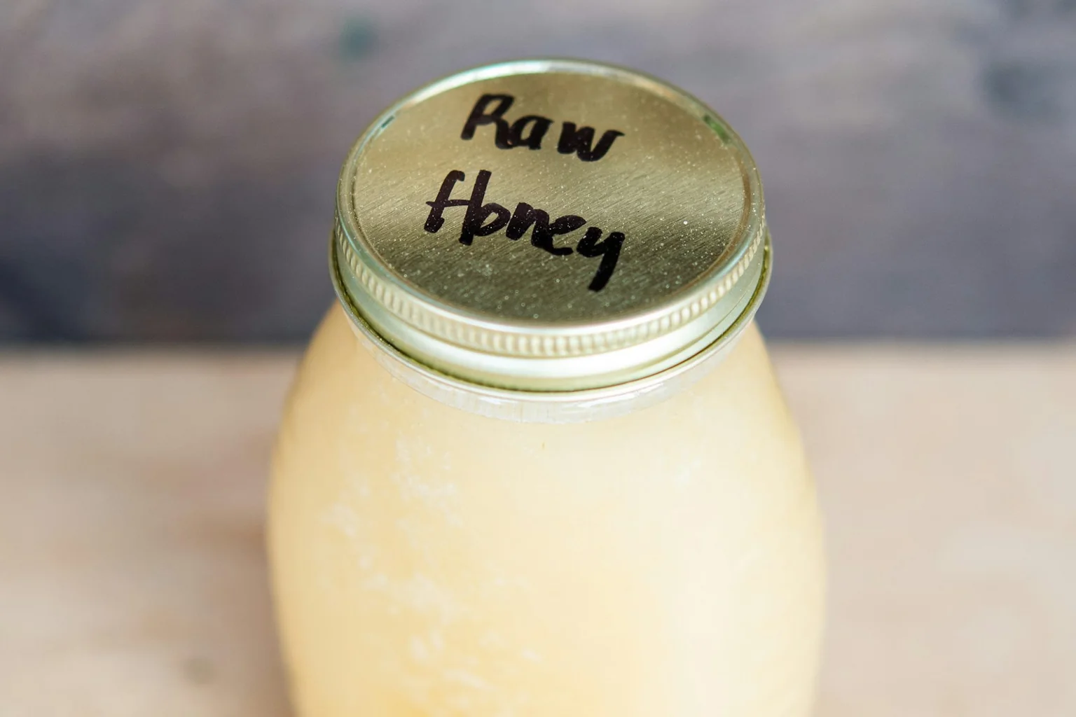A jar of raw honey with a handwritten lid